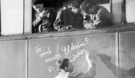 1945, απελευθέρωση. Τρένο στον σταθμό της Βαϊμάρης μεταφέρει παιδιά που επιβίωσαν στο Άουσβιτς. Ένα παιδί γράφει με κιμωλία: «Πού είναι οι γονείς μας; Δολοφόνοι!»
